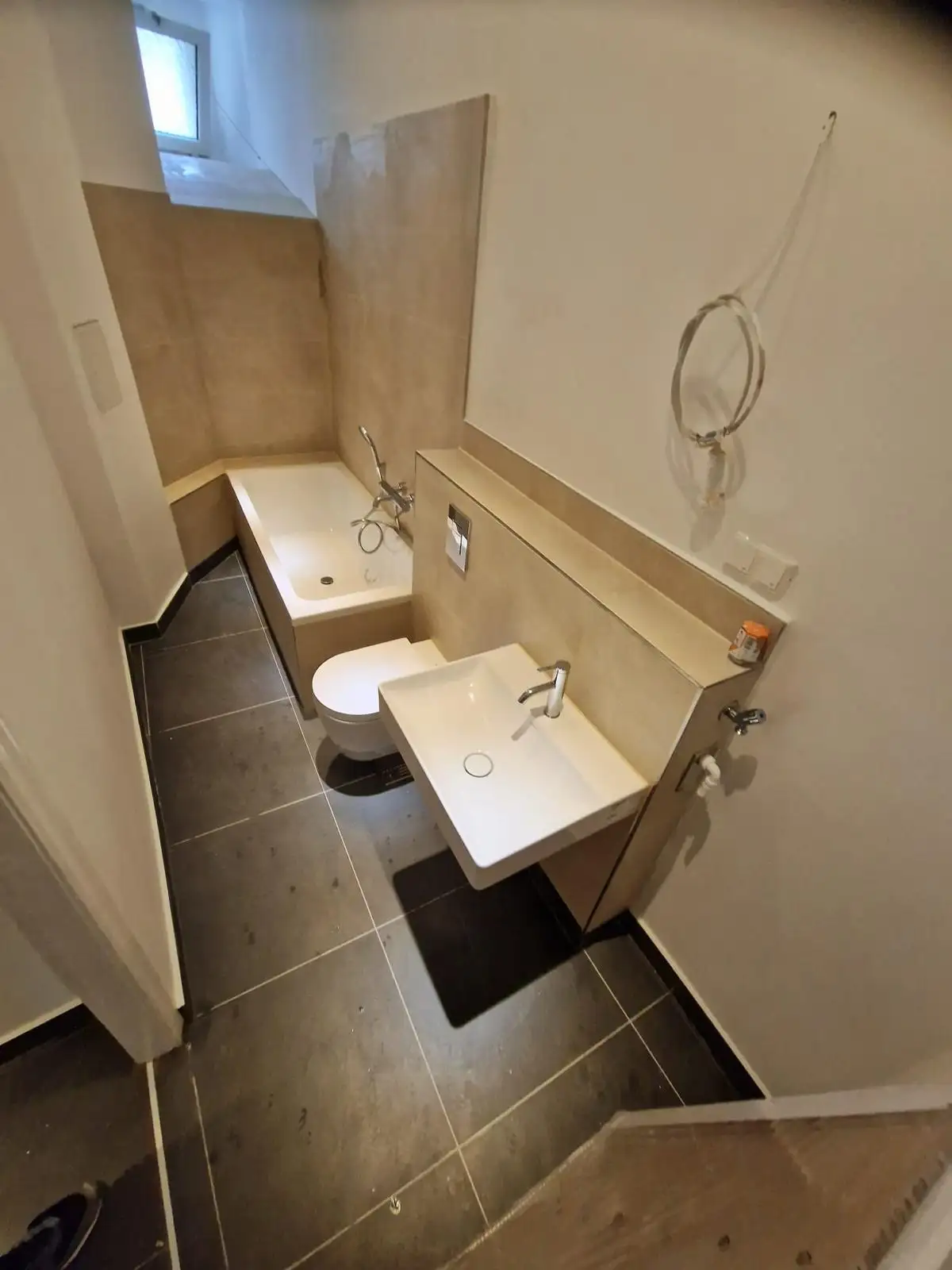 Neues Bad mit Wanne, WC und modernen Fliesen nach der Sanierung