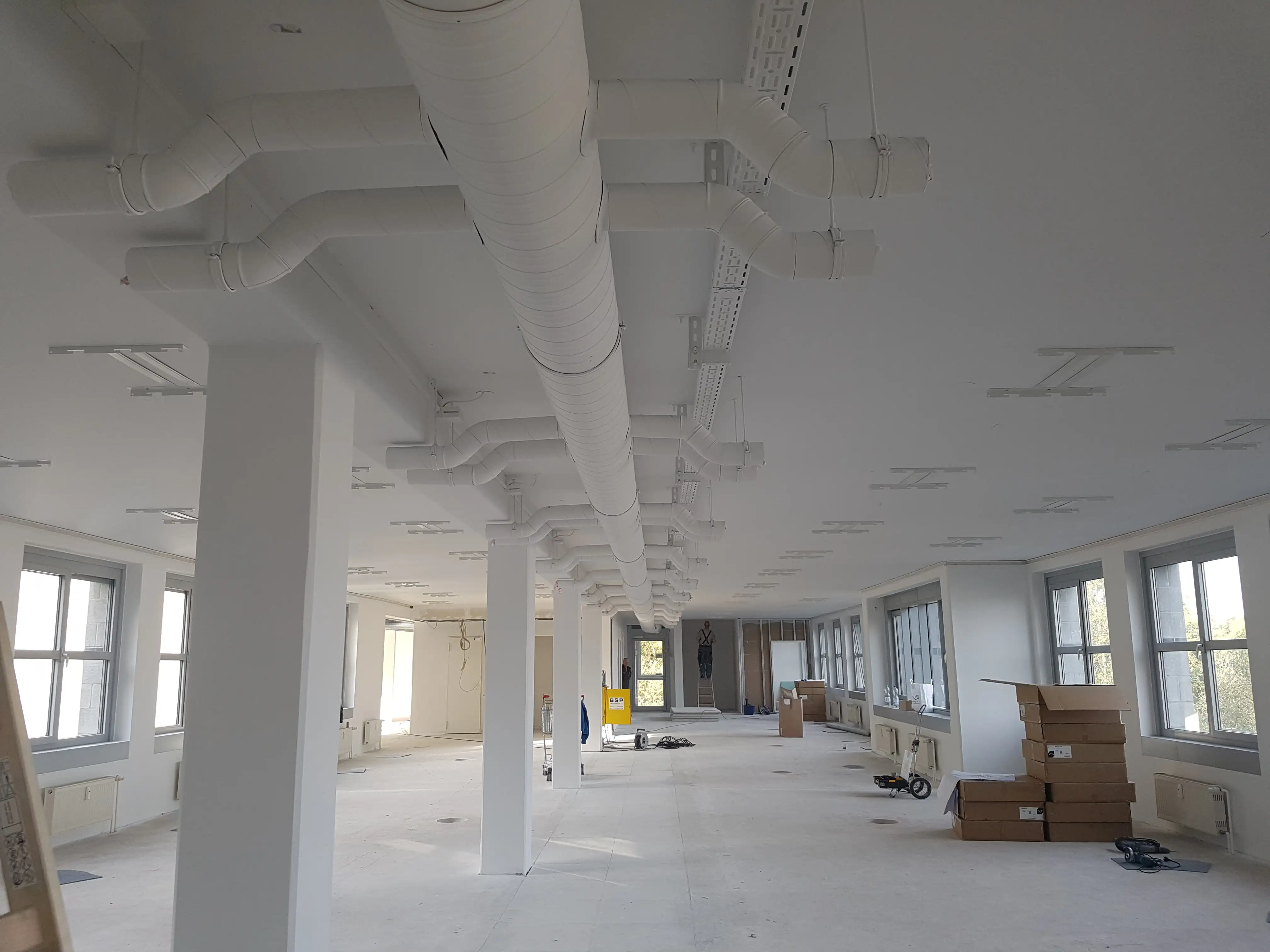 Weiß beschichtete Sichtinstallation der Lüftung im ausgebauten Großraum